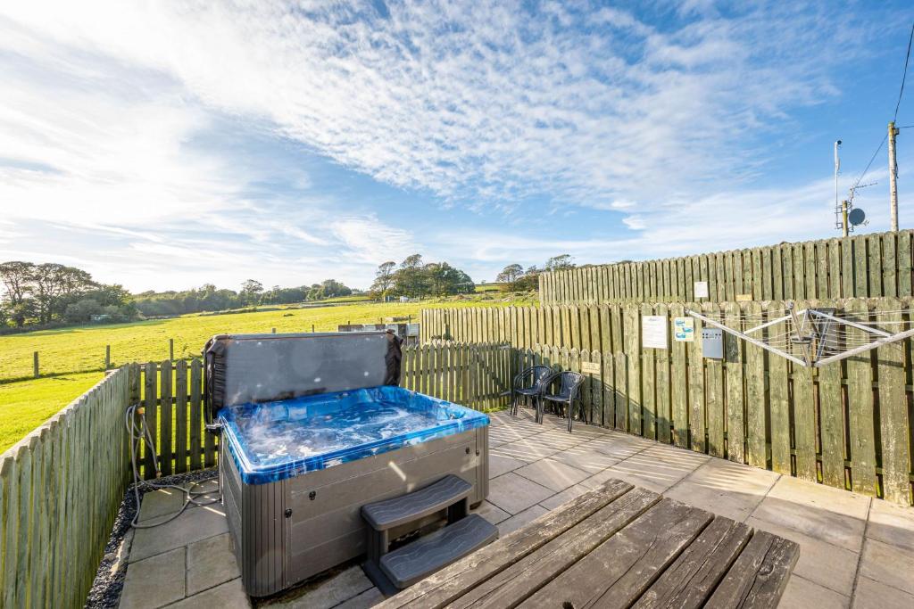a cooler sitting on a patio next to a fence at Auchenlarie Courtyard No 1 in Gatehouse of Fleet