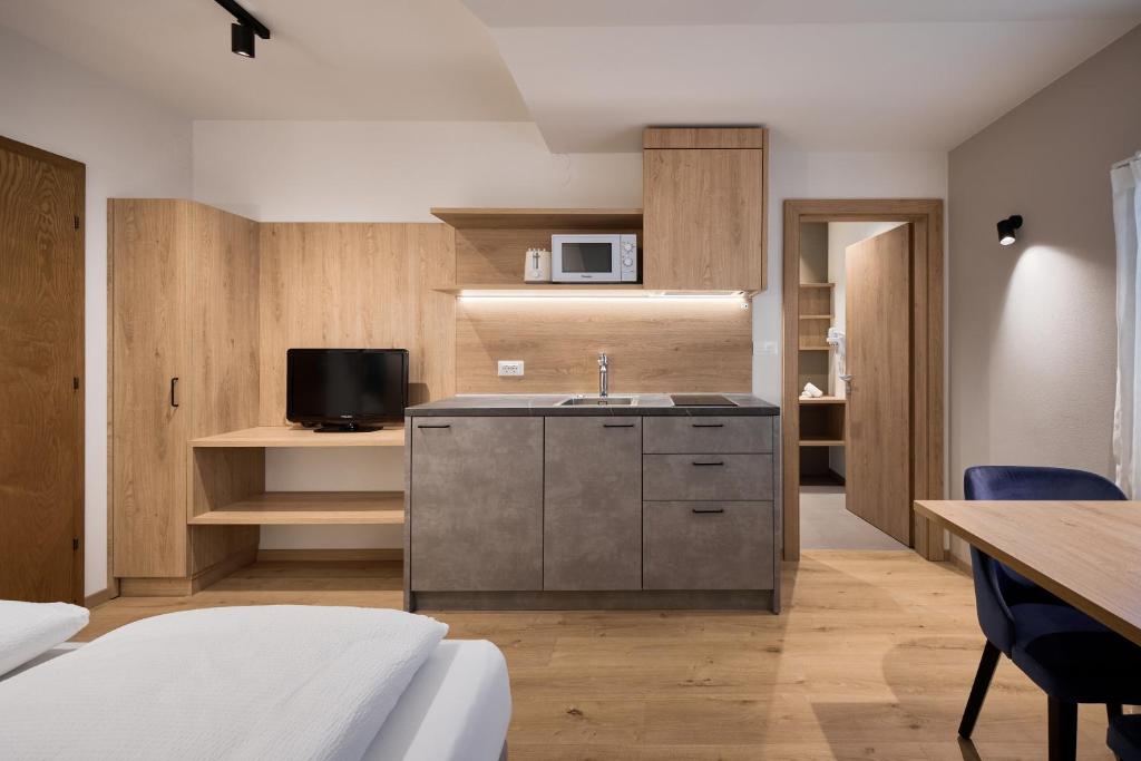 kuchnia ze zlewem i telewizor w pokoju w obiekcie Apartment Steinach w mieście Lagundo