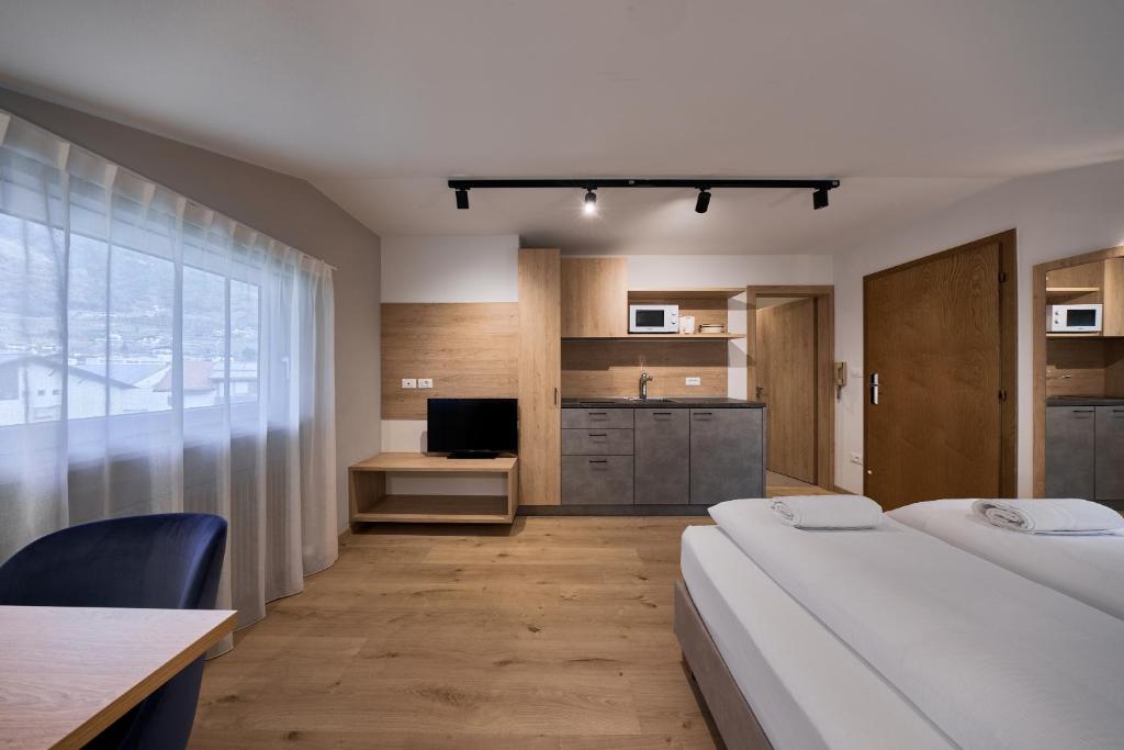 pokój hotelowy z 2 łóżkami i kuchnią w obiekcie Apartment Steinach w mieście Lagundo