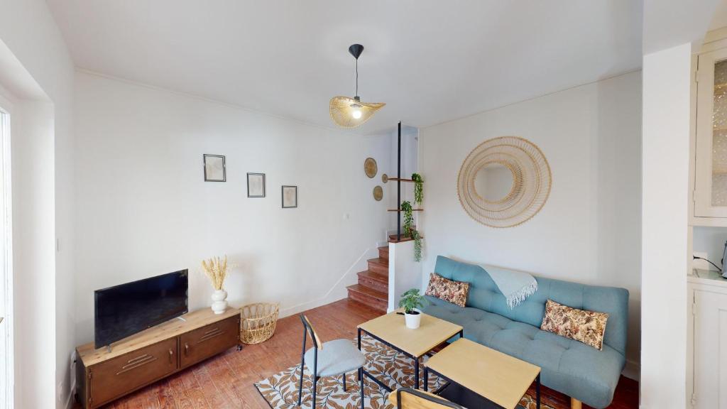 un salon avec un canapé bleu et une table dans l'établissement Maison Beau Site, au Havre