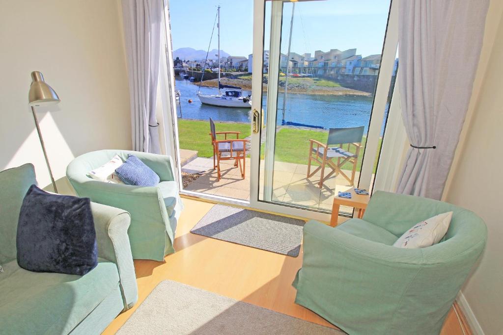 - un salon avec des chaises et une vue sur l'eau dans l'établissement Harbour Escape, à Porthmadog
