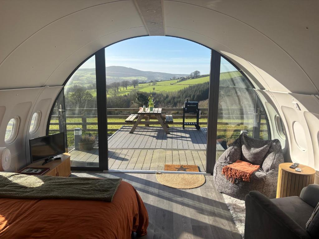 una camera con una grande finestra ad arco con vista su un patio di Sky High Glamping a Shillelagh