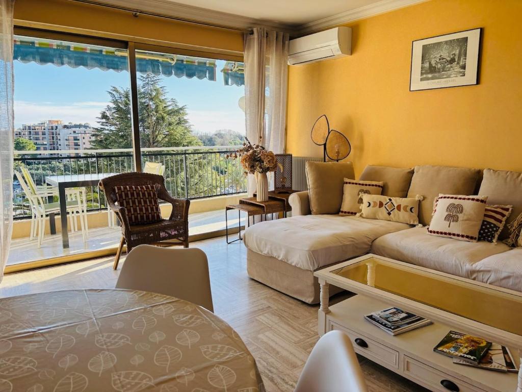 un salon avec un canapé et une table dans l'établissement Le Pamplemousse - Stunning 1 Bedroom Quiet Pool, à Mandelieu-la-Napoule