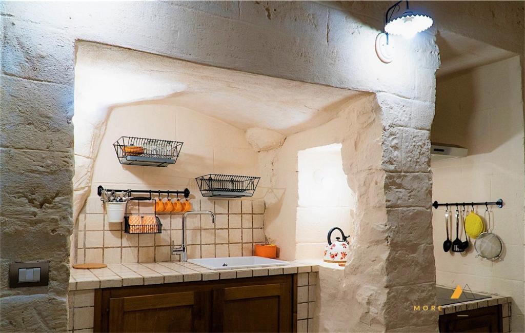 Una cocina con fregadero y una pared de piedra. en More Apartments The Castle, en Bari