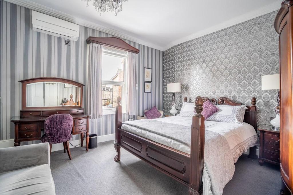 a bedroom with a bed and a desk and a mirror at Tower Guest House in York