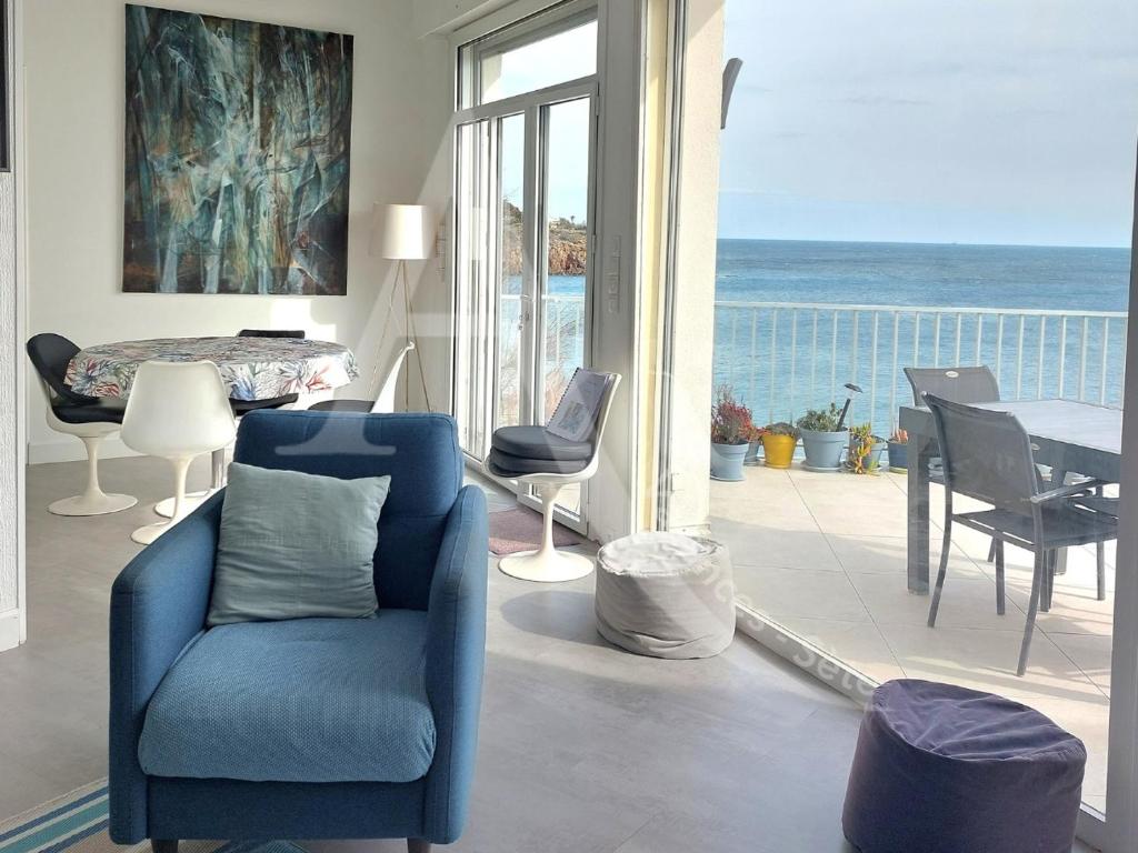 - un salon avec une chaise bleue et une vue sur l'océan dans l'établissement 3 chambres internet stationnement situation unique en 1ere ligne mer, à Sète