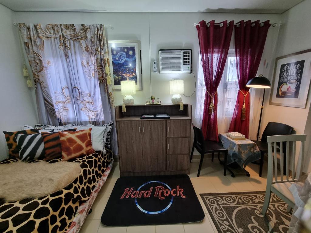 a room with a bed and a desk and curtains at Condo for Rent Cheer Residences in Marilao