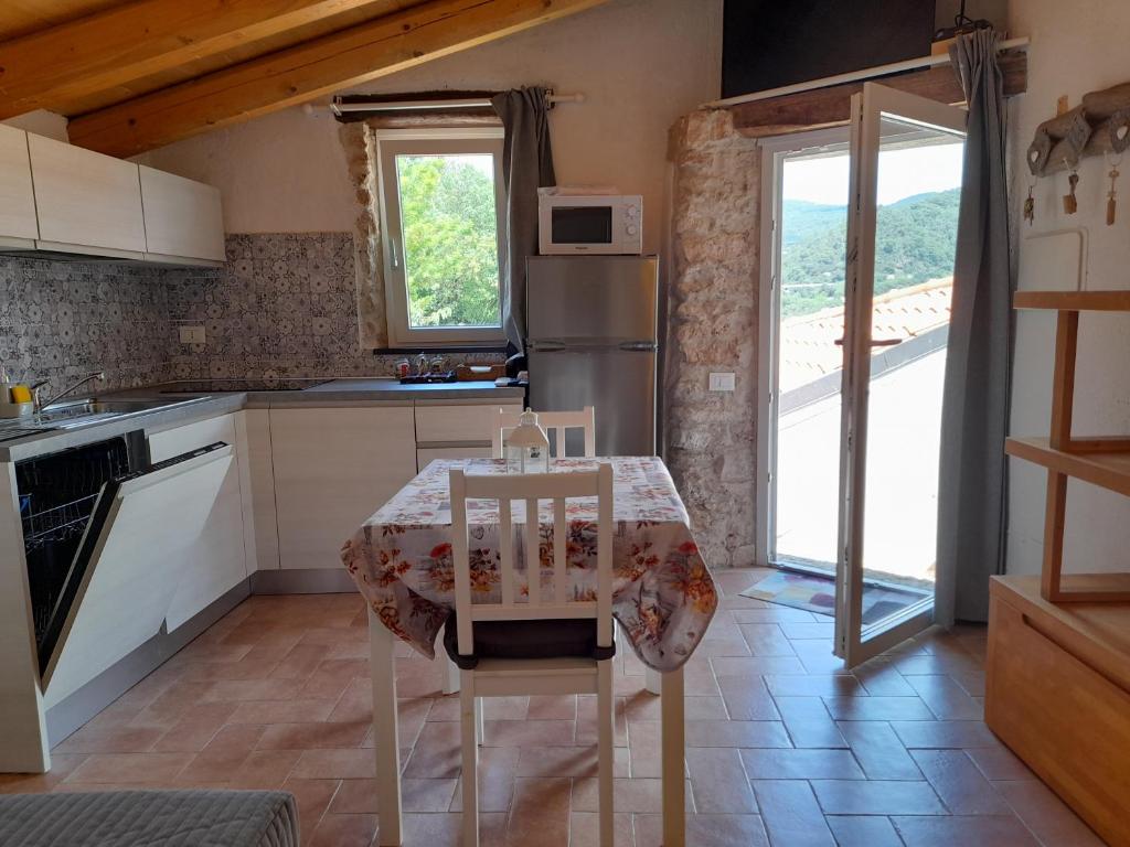 a kitchen with a table and a refrigerator at Cà di Pippo "Riccio" appartamento Loc Boragni Orco Feglino in Vezzi Portio