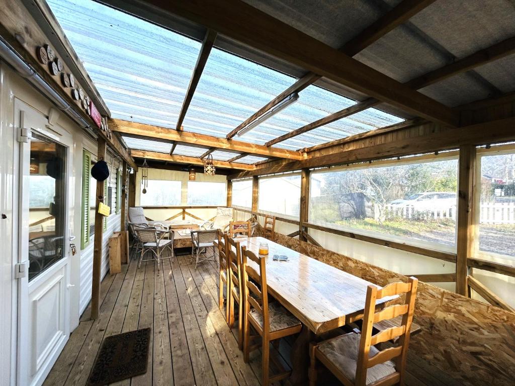 - une véranda avec une table et des chaises en bois dans l'établissement Charmant Mobile-home 6 personnes sur terrain privé à Guidel-Plages - ROZVEN, à Guidel