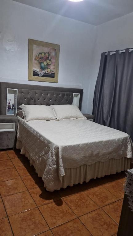 a bedroom with a bed with a gray headboard at Casa da bisa Élida in São Gabriel