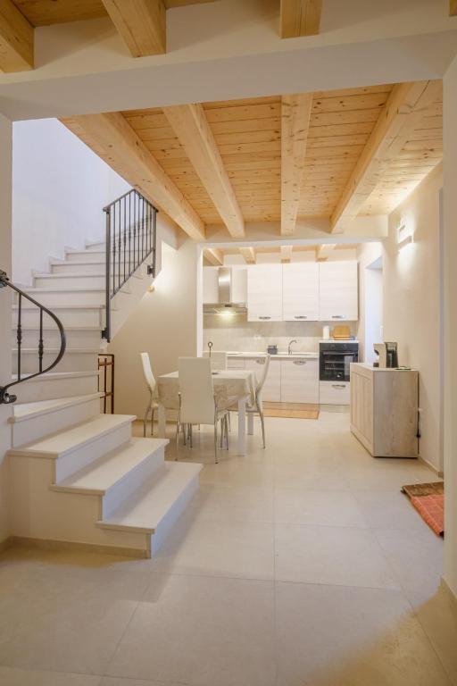 a kitchen and dining room with stairs and a table at La Casa di Vina in Fermo