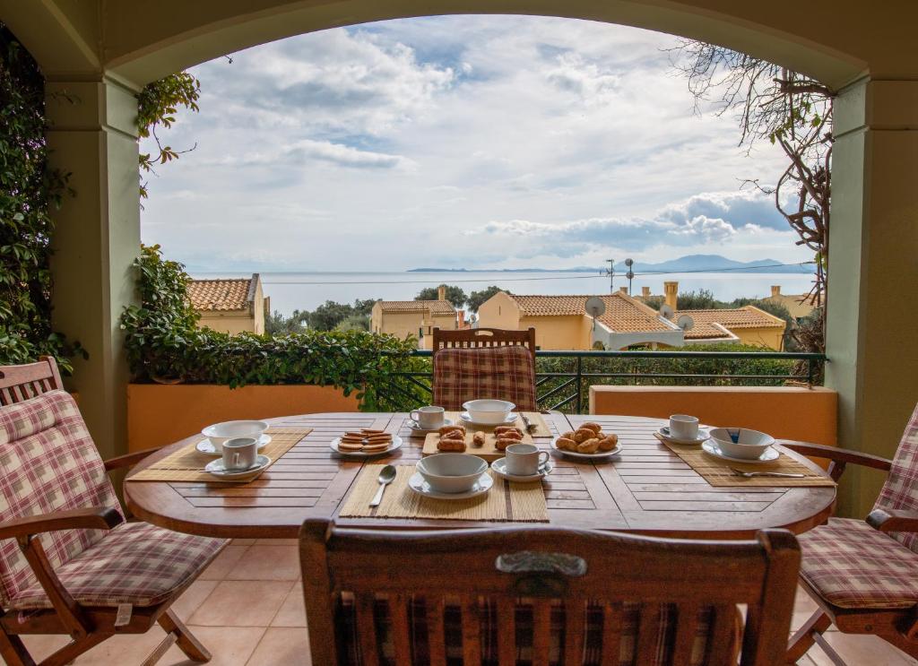 a table on a patio with a view of the ocean at Barbati Angela's Garden Sea View in Barbati