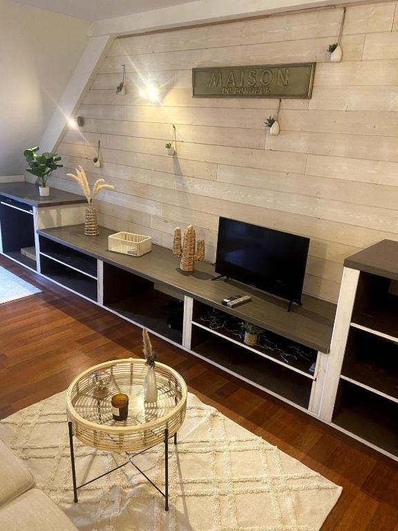 un salon avec une télévision à écran plat sur un mur dans l'établissement Charmant T3 à Bagnères-de-Luchon, à Luchon