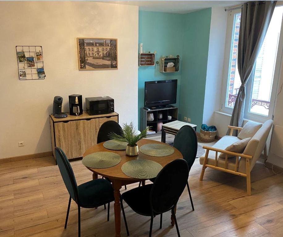 un salon avec une table et des chaises de salle à manger dans l'établissement Le 12 Epernay, à Épernay