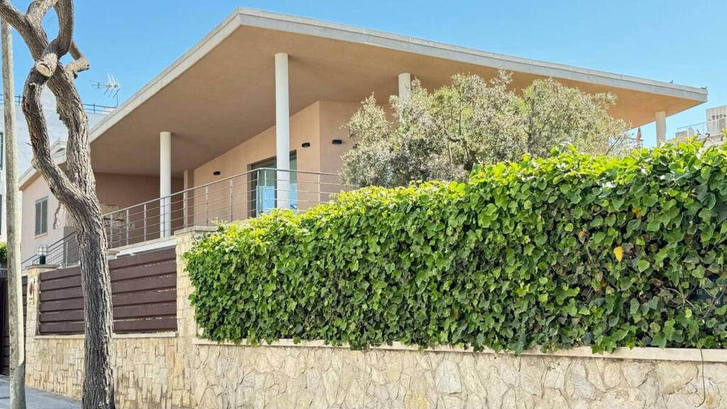a house with a hedge in front of a building at Best Leisure in Playa de Palma in Can Pastilla
