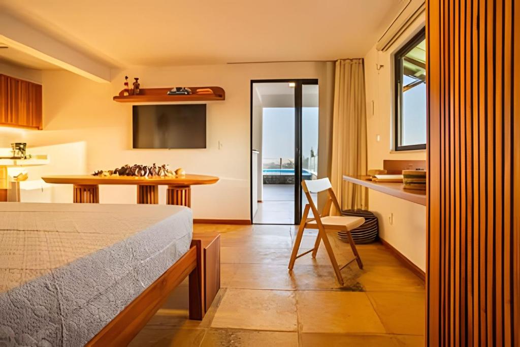 una camera da letto con un letto e una cucina con un tavolo di Arara house 4 a Jericoacoara