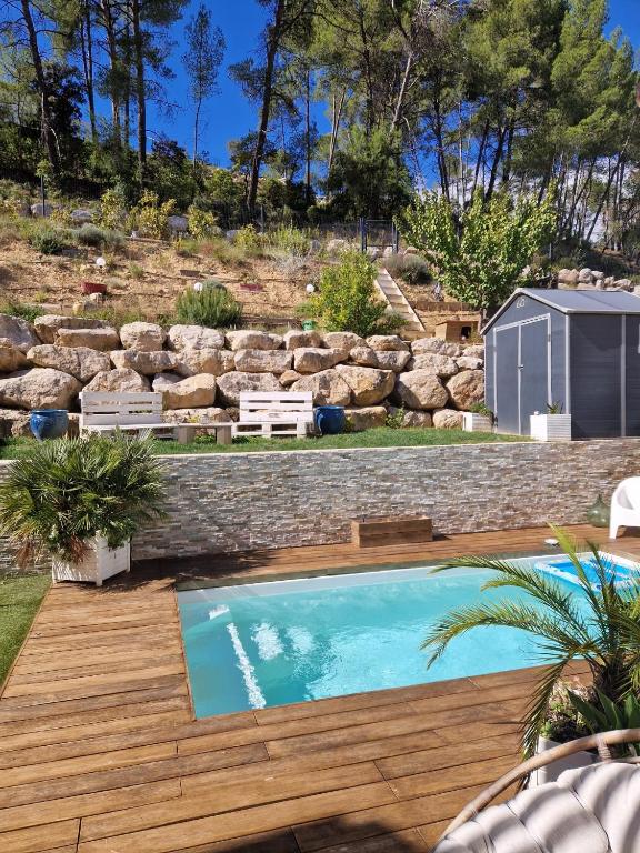 une cour arrière avec une piscine et une terrasse en bois dans l'établissement Jolie villa paisible, à Montferrier-sur-Lez