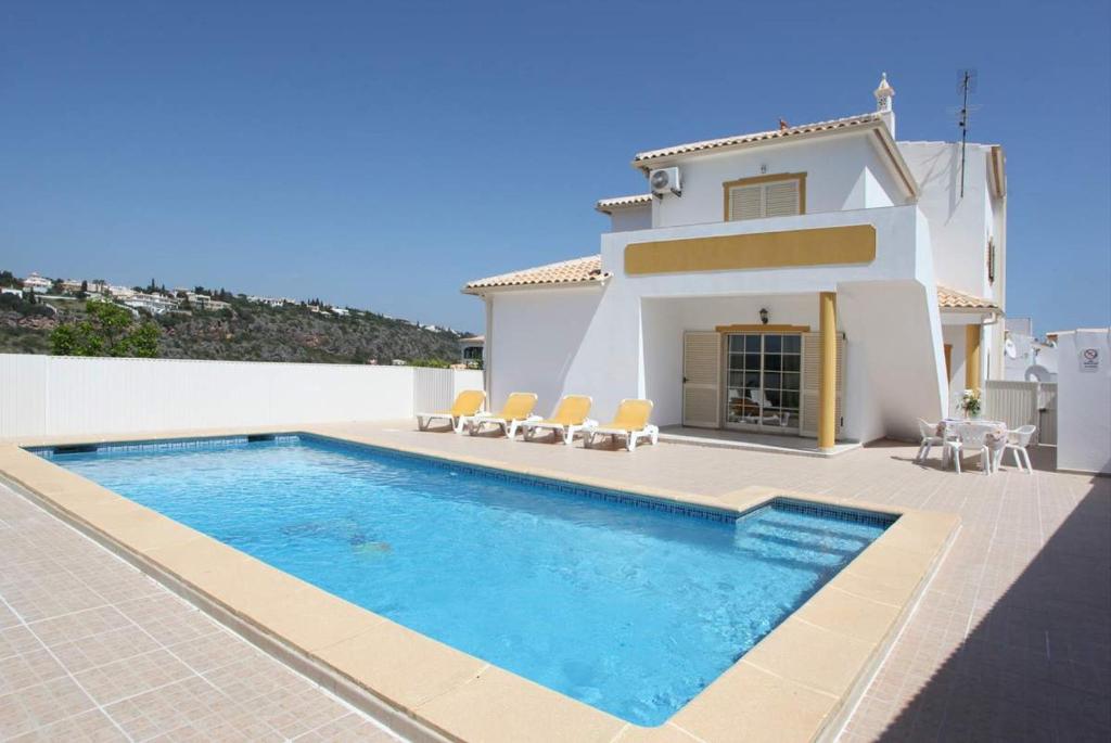 a villa with a swimming pool in front of a house at Villa Da Duarte - walkable to beach shops bars in Albufeira