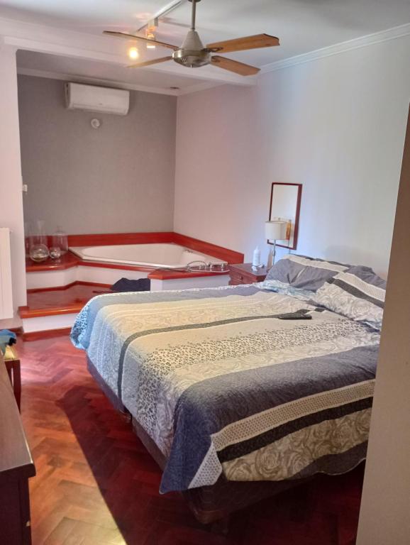 ein Schlafzimmer mit einem Bett und einem Deckenventilator in der Unterkunft CASA RIO TERCERO Cordoba Argentina in Río Tercero