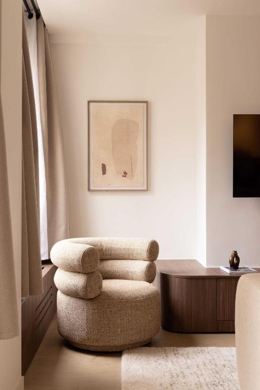 un salon avec une chaise et une table dans l'établissement Elegant apartment - AC- 2BR-6P- Madeleine, à Paris