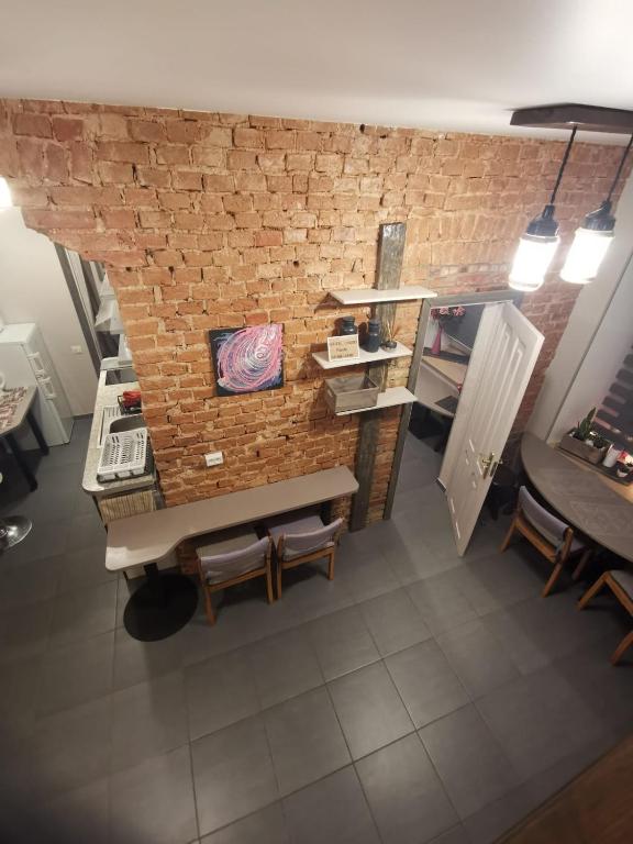 a room with a brick wall and a table and benches at Alejas KAMBARI in Myza Bene