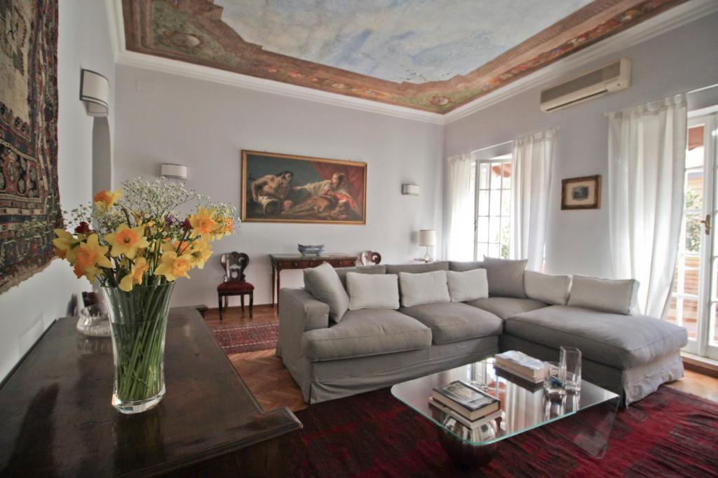 ローマにあるAt Roman Penthouseのリビングルーム(ソファ、花のテーブル付)
