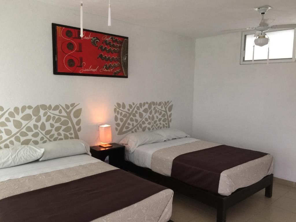 1 dormitorio con 2 camas y una foto en la pared en Quinta Souffle, en Xochitepec