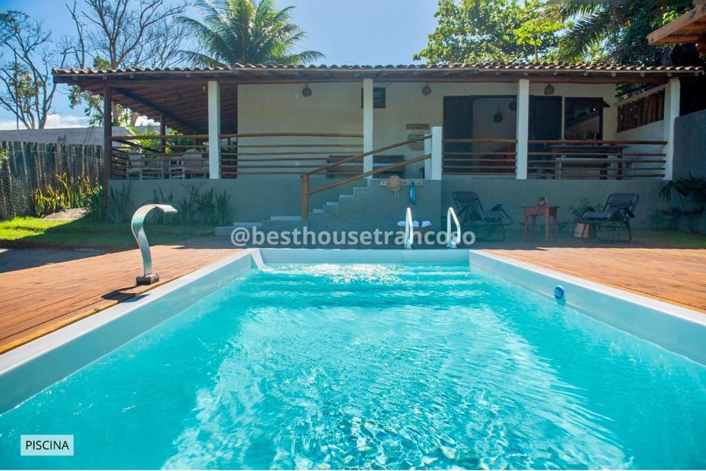 a swimming pool in front of a house at Best House Trancoso in Porto Seguro