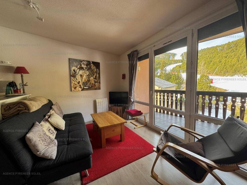 d'un salon avec un canapé et un balcon. dans l'établissement Appartement 2* 6 Couchages au Pied des Pistes avec Balcon et Parking – Les Angles - FR-1-295-178, aux Angles