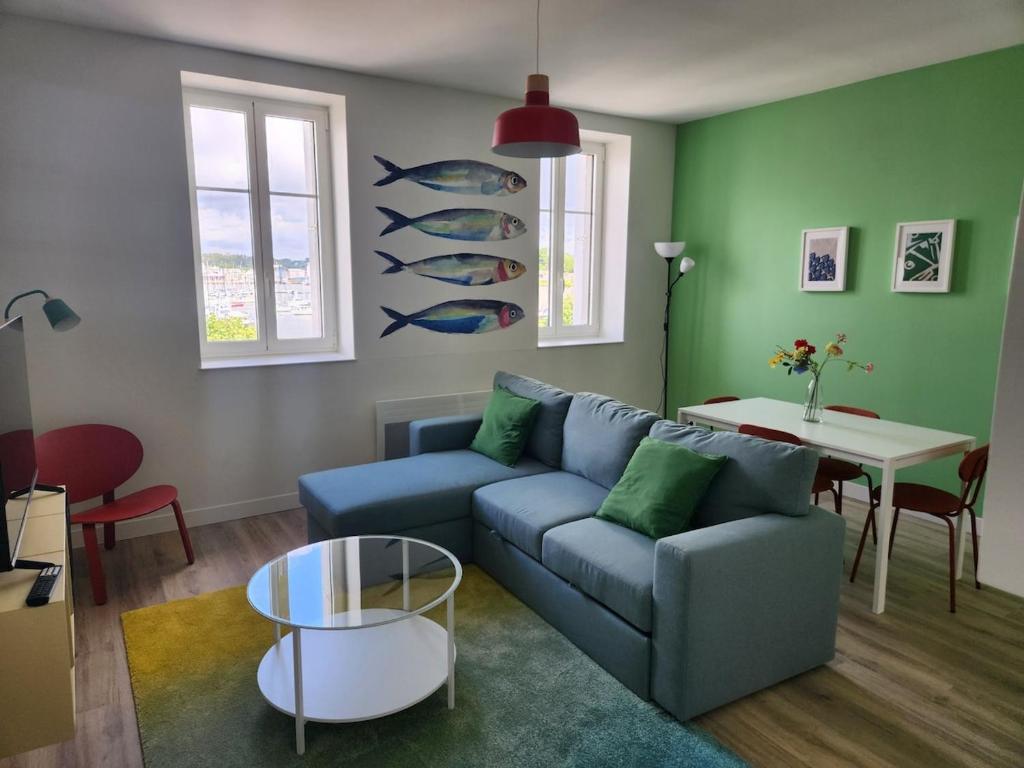 a living room with a blue couch and a table at 3- Vue sur le port, la ville close, confort, WIFI in Concarneau