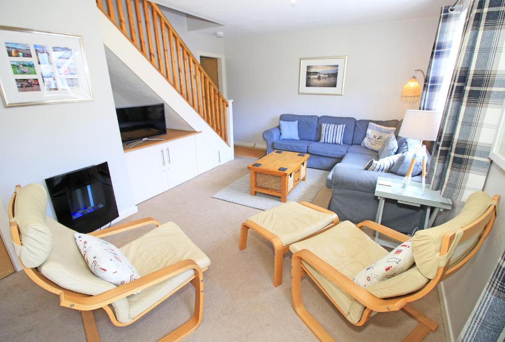 a living room with chairs and a blue couch at Green Cottage in Porthmadog