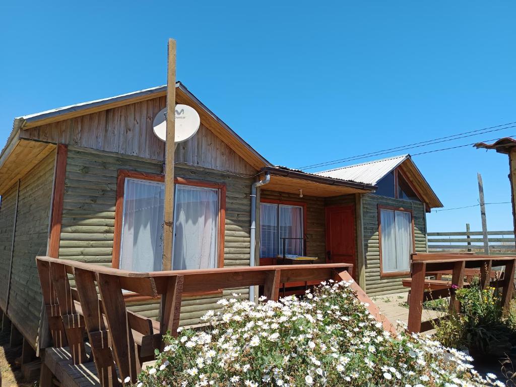 a log cabin with a porch and a deck at Cabaña lagunillas in Matanzas