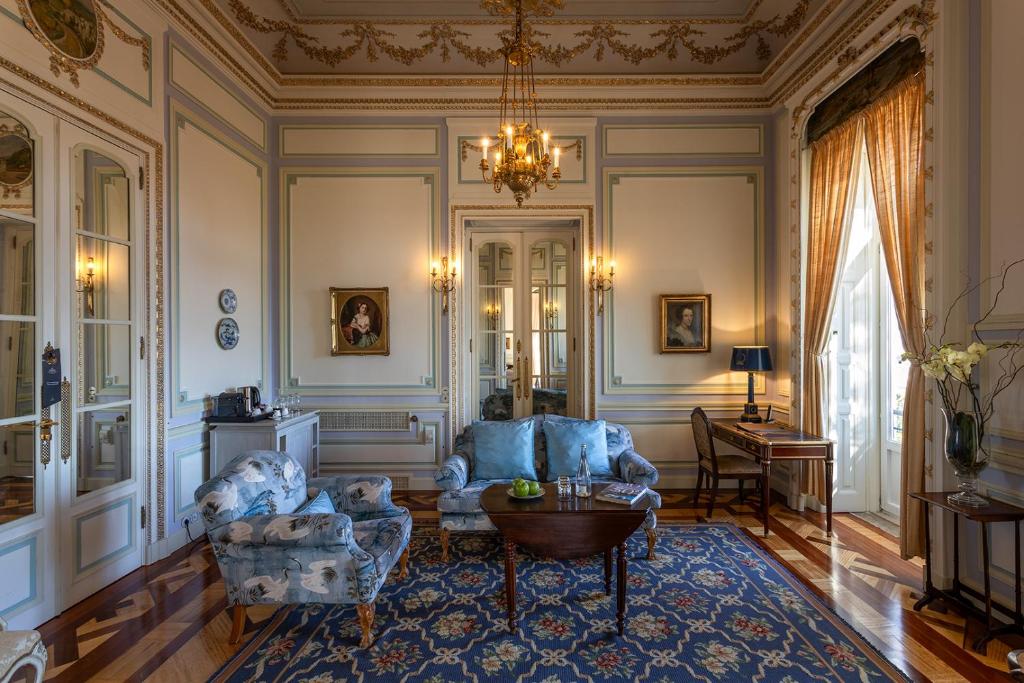 A refined sitting room with a writing desk, sofas and period portraits.
