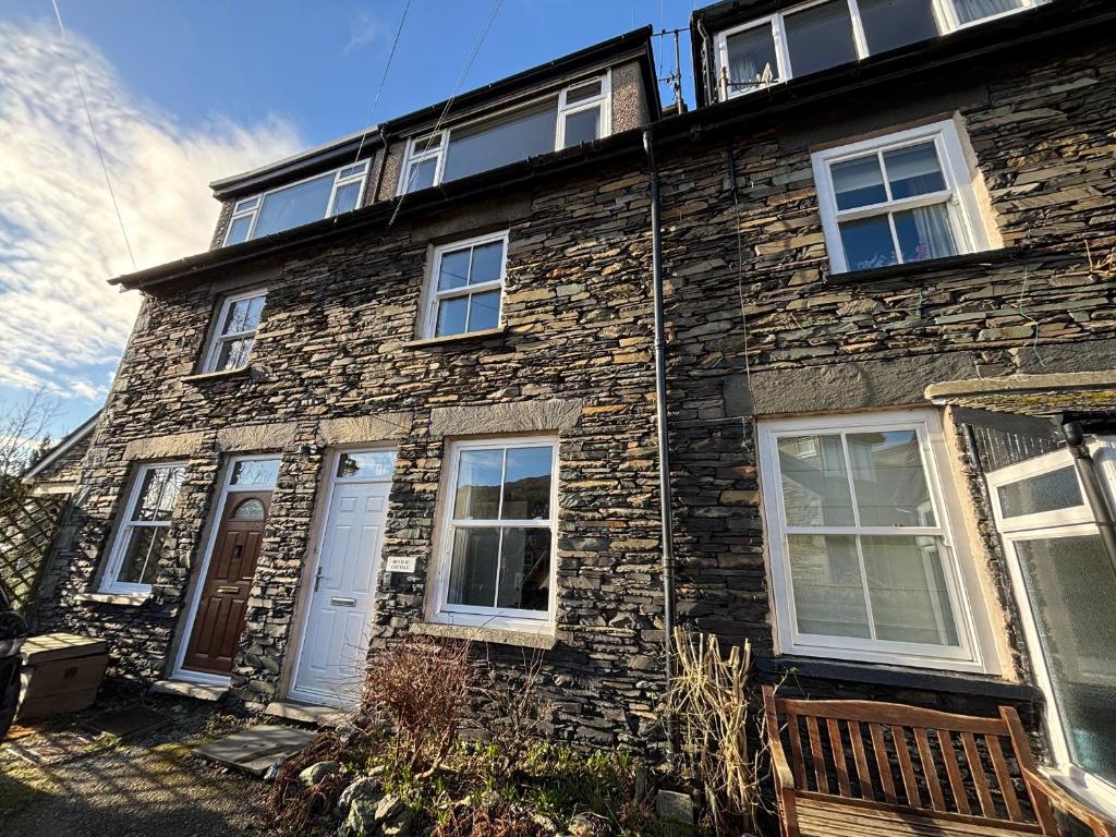 a brick building with a white door and windows at Rothay Cottage in Ambleside