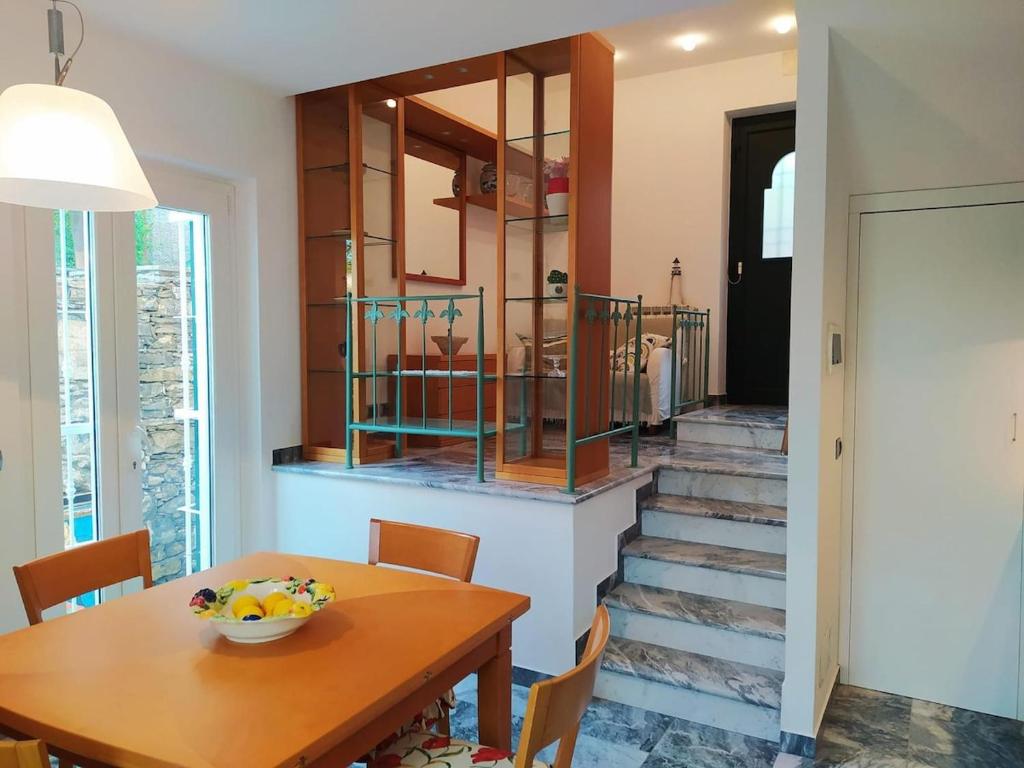 une salle à manger avec une table en bois et un escalier dans l'établissement Casa Margherita parking, à Zoagli