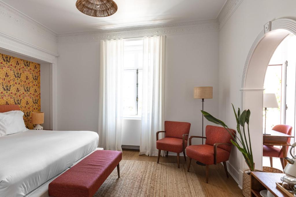 a hotel room with a bed and two chairs at Pergola Boutique Hotel in Cascais