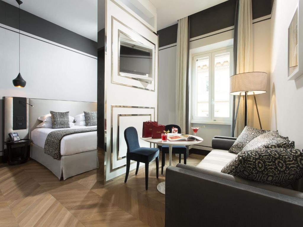 a hotel room with a bed and a couch and a table at Corso 281 Luxury Suites in Rome