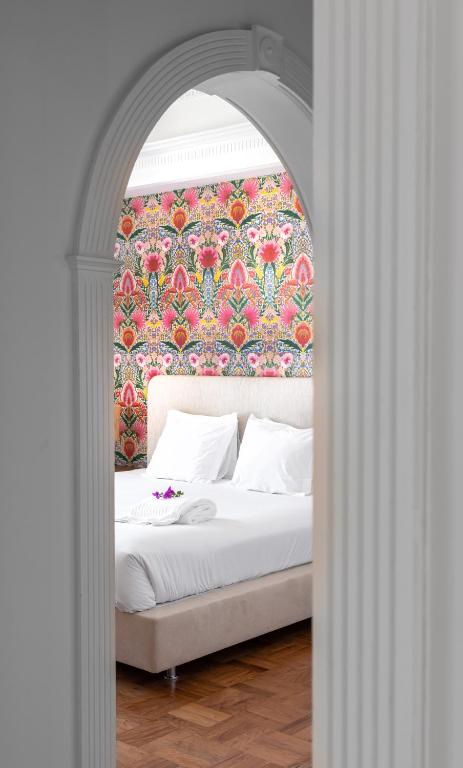 a bedroom with a bed with a floral wallpaper at Pergola Boutique Hotel in Cascais