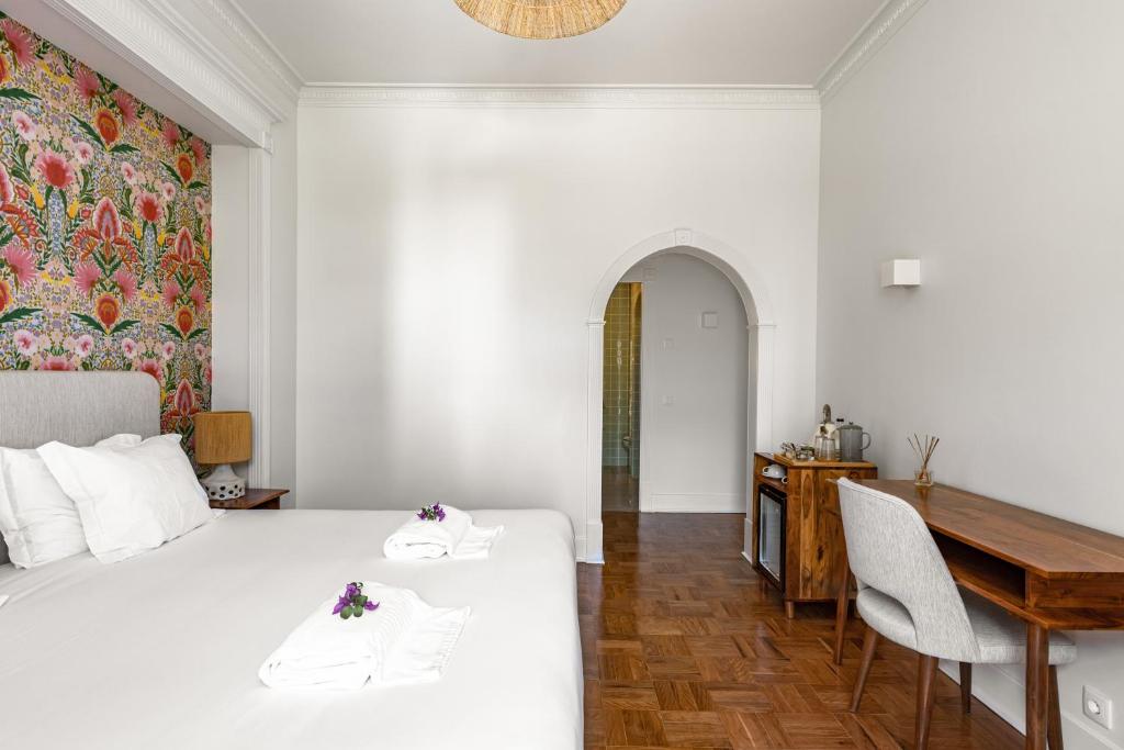 a bedroom with a bed and a desk and a table at Pergola Boutique Hotel in Cascais