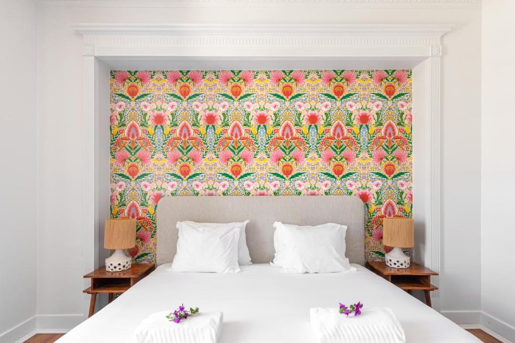 a bedroom with a large bed with a floral wallpaper at Pergola Boutique Hotel in Cascais