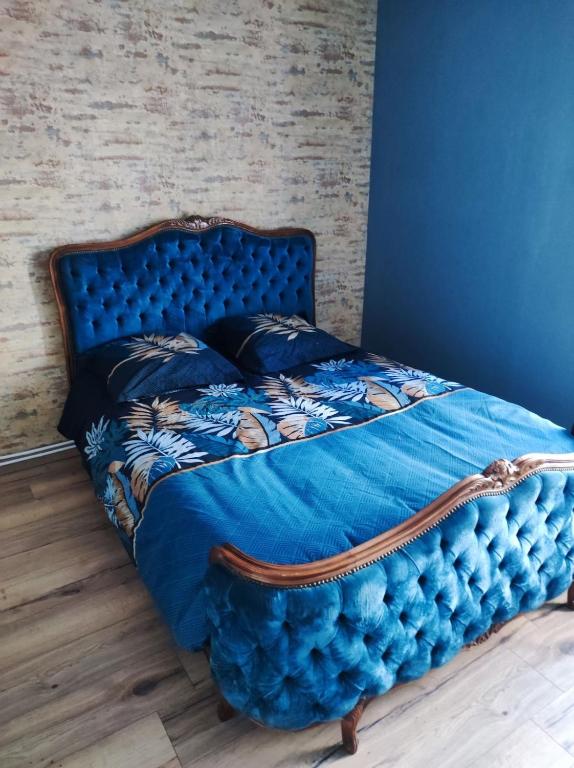 - un lit bleu dans une chambre avec un mur en briques dans l'établissement Appartement 4 personnes proche du château fort, à Sedan