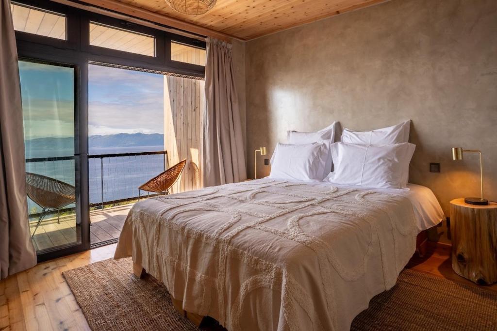 una camera da letto con un letto grande e una grande finestra di Casa da Faia a São Roque do Pico