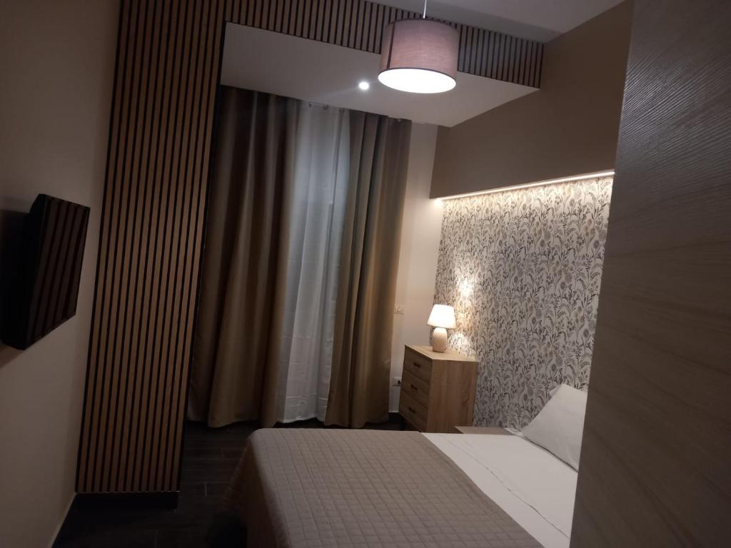 DONNA MELA apartments في بارشلونا-بوتسو دي غوتو: غرفة فندقية فيها سرير ومصباح وستائر