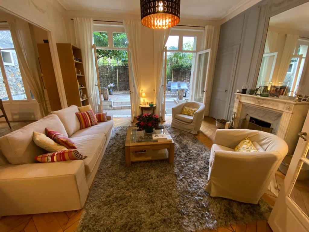 Elle comprend un salon doté d'un mobilier blanc et d'une cheminée. dans l'établissement Magnifique appartement avec terrasse à côté de la Tour Eiffel, à Paris