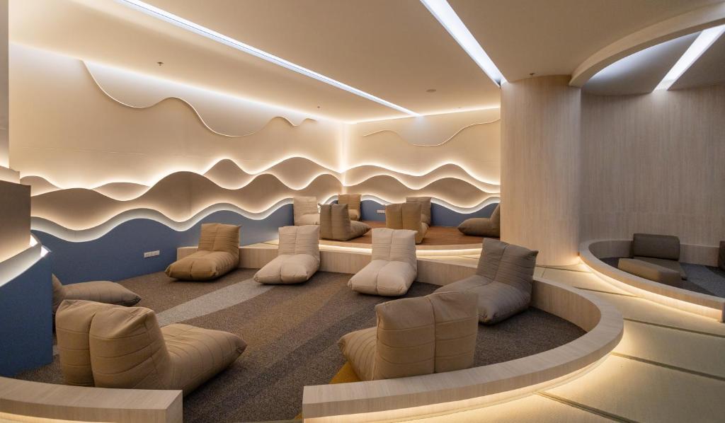 A softly lit lobby lounge offers low upholstered seats around a curved waiting area.