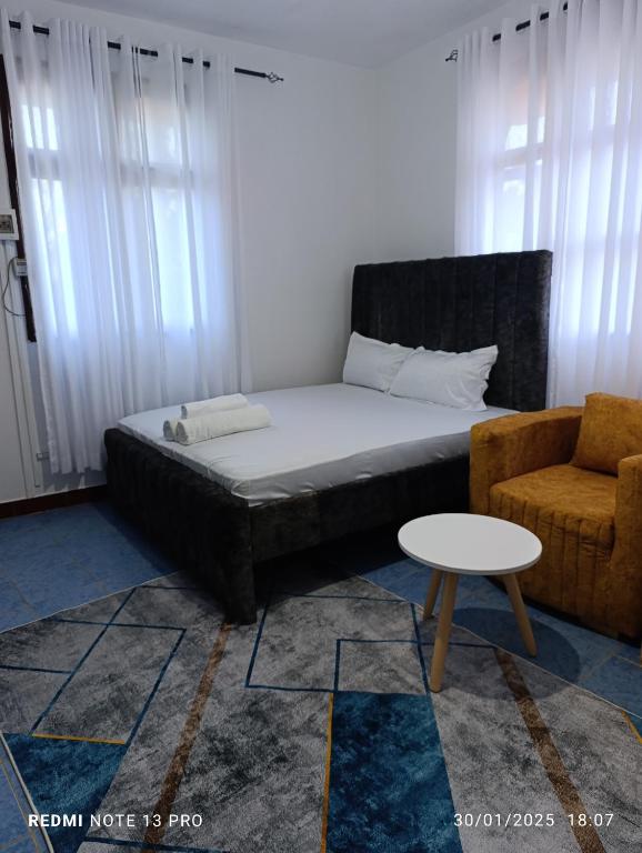 una camera da letto con un letto, un divano e un tavolo di Malaika Diani Homes a Ukunda