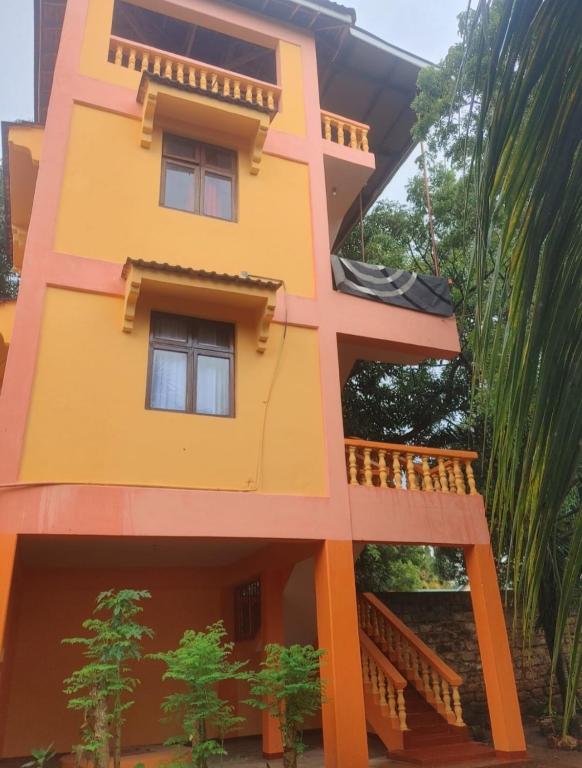 un modello di casa gialla con balcone di Malaika Diani Homes a Ukunda