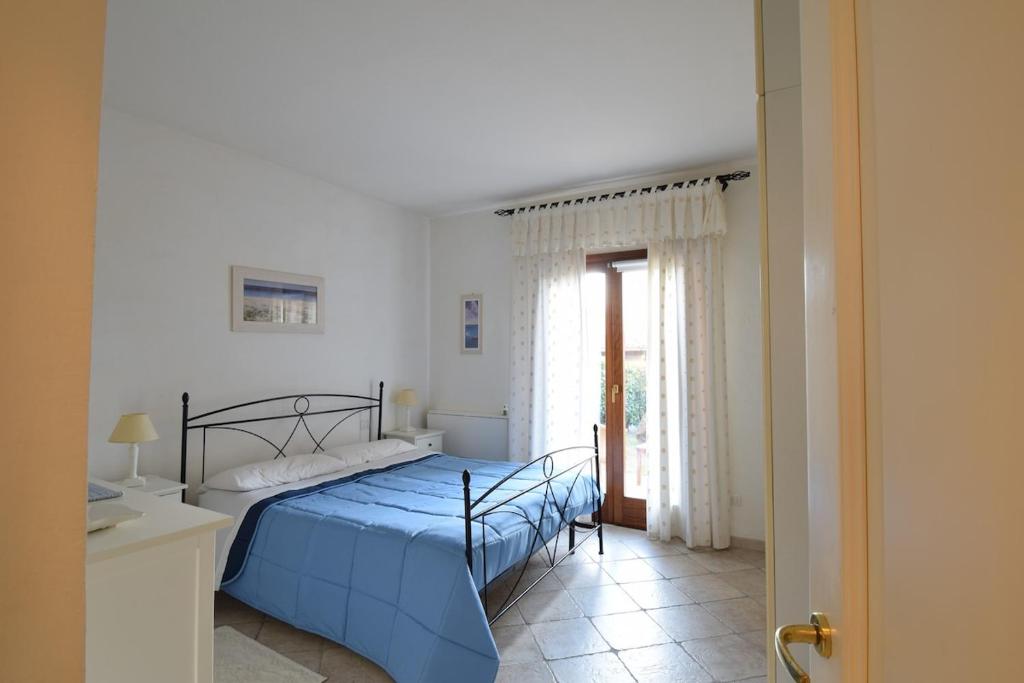 a bedroom with a blue bed and a window at Bellissima villa piscina 8 pax 1500 mt dal mare FMP-CAT01-PI in Monte Petrosu