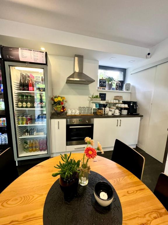 a kitchen with a wooden table with a refrigerator at Hotel Vincent in Luhačovice