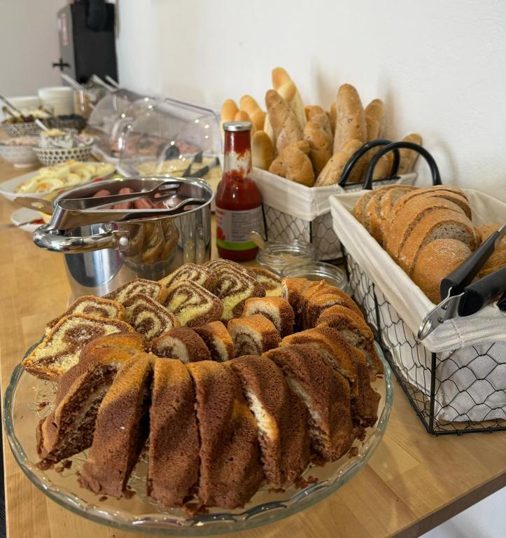 a table topped with bread and baskets of pastries at Hotel Vincent in Luhačovice